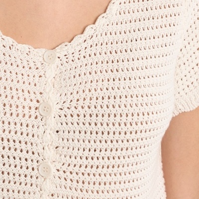 Blusa feminina creme de malha crochetada com botões frontais e detalhe ondulado no decote