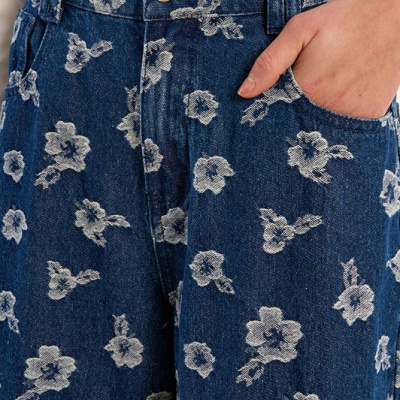 Calças de ganga azul com padrão de flores brancas e bolso frontal