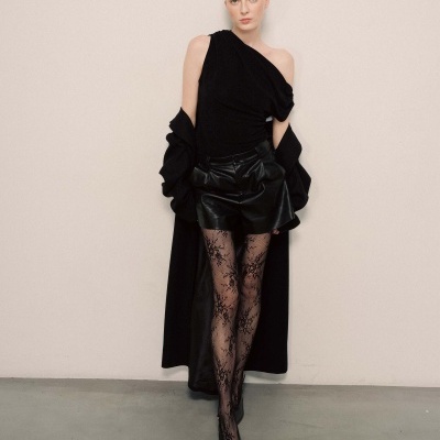 Mulher com roupa preta elegante e collants com padrão floral