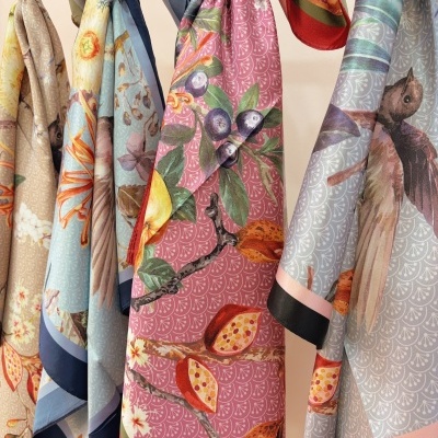 Lenços coloridos com estampas florais e de pássaros pendurados