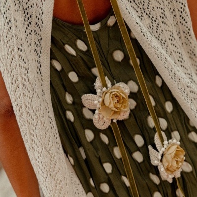 Vestido verde com bolinhas brancas, flores de tecido bege e malha branca entrelaçada