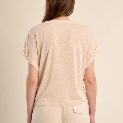 Mulher de costas com t-shirt bege e calças claras