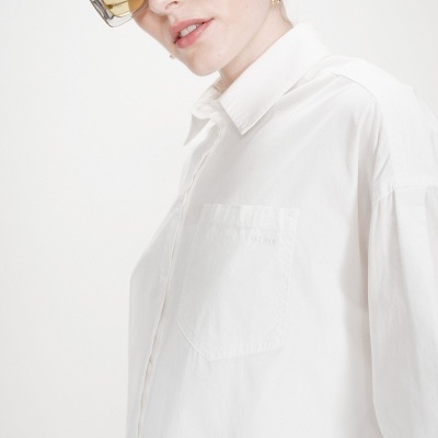 Camisa branca com bolso no peito e óculos com lentes amarelas