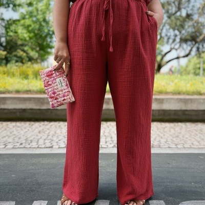 Calças vermelhas texturizadas, sandálias castanhas, blusa branca e carteira rosa estampada AMOUR VOU