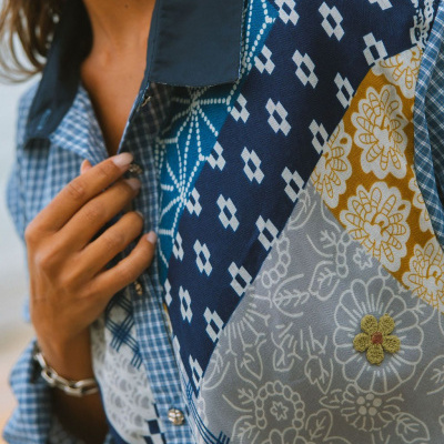 Blusa com padrão patchwork em tons de azul, branco, amarelo e cinza