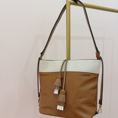 Mala de ombro castanha com parte superior branca, alça ajustável e decorações penduradas