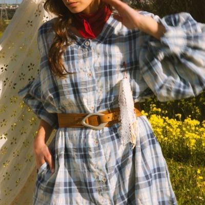 Vestido xadrez azul e bege com botão, cinto castanho e lenço vermelho ao pescoço