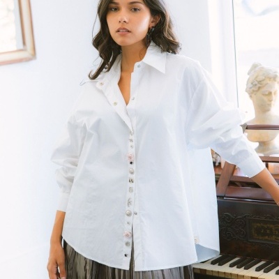 Blusa branca de algodão com botões decorativos e saia plissada cinza