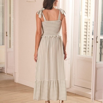 Vestido longo às riscas bege e branco com alças atadas nos ombros, visto de costas.