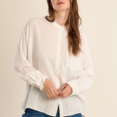 Camisa feminina branca em tecido leve com botões e bolso, combinada com calças jeans azuis