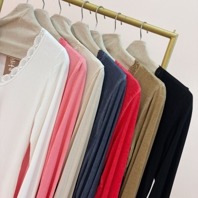 Blusas de manga comprida com gola em renda em várias cores penduradas num cabide dourado