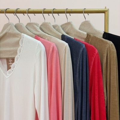 Camisas coloridas de manga comprida com gola de renda penduradas no cabide