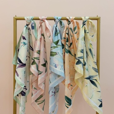 Seis lenços florais pendurados num suporte dourado