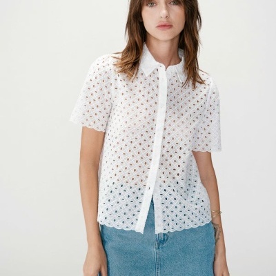 Camisa branca de renda com padrão circular e saia de ganga azul clara