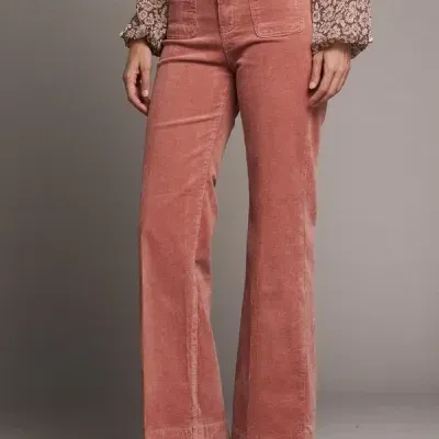 Calças de veludo cor-de-rosa com bolsos frontais quadrados e blusa estampada