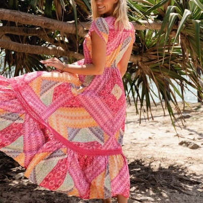 Vestido comprido feminino com padrão patchwork colorido numa praia