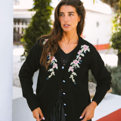 Casaco preto com bordado floral e botões azuis, modelo exterior