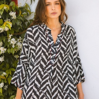 Blusa com padrão preto e branco, botões frontais e manga três quartos