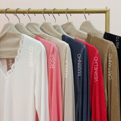 Blusas de manga comprida de várias cores penduradas num cabide amarelo