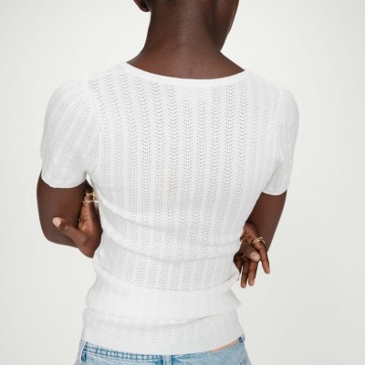 Mulher de costas com camisola branca e jeans azul claro