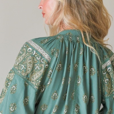 Blusa feminina verde com padrão floral e motivos cachemira vista de costas