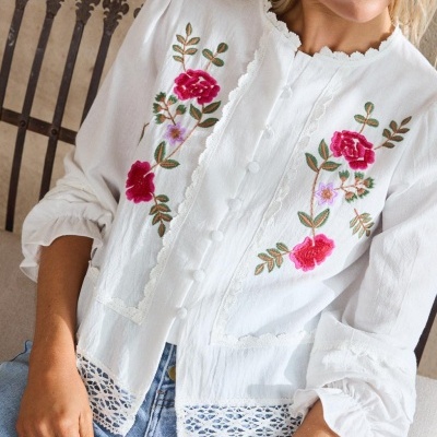 Blusa branca com bordados florais e renda usada com jeans azuis