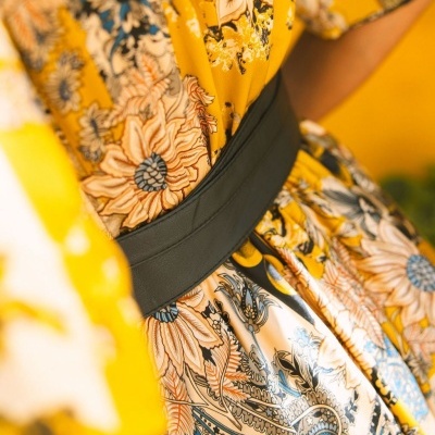 Vestido amarelo com padrão floral e cinto preto largo