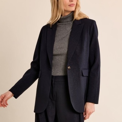 Mulher com blazer preto, camisola cinzenta e calças largas pretas