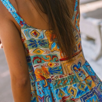 Vestido de alças colorido com padrão abstrato usado por mulher