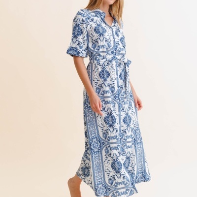 Mulher com vestido comprido azul e branco com padrão floral.