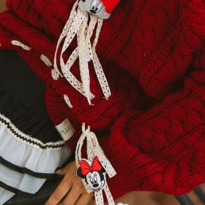 Camisola vermelha de malha grossa com fitas bege e detalhes Minnie Mouse junto a saia preta e branca