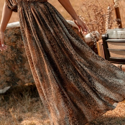 Vestido longo animal print castanho e preto com cintura franzida e botas castanhas ao ar livre