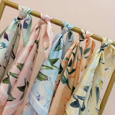 Lenços de seda florais pendurados em varão dourado