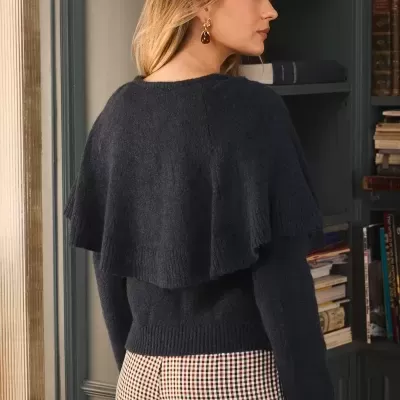 Mulher de costas com camisola preta e calças xadrez