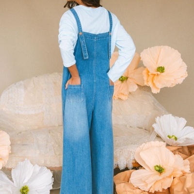 Macacão de ganga azul claro com alças e bolsos visto de costas