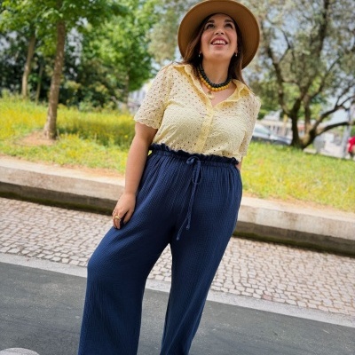 Mulher com roupa casual colorida e chapéu em parque