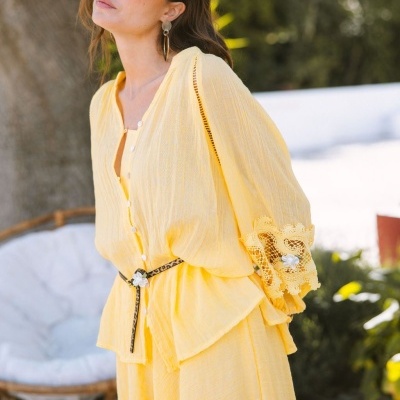 Conjunto amarelo de blusa e calças com detalhes rendados e cinto animal print
