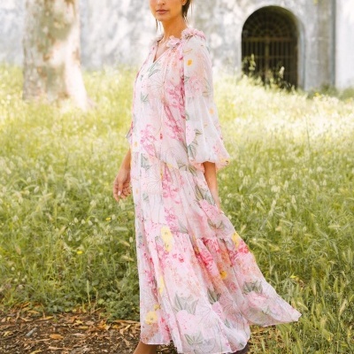 Vestido comprido com padrão floral rosa e amarelo em ambiente exterior