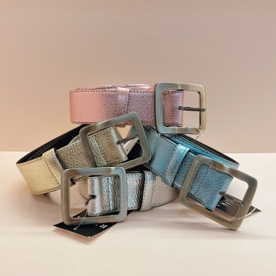 Cinco cintos metálicos coloridos com fivela quadrada prateada sobre superfície branca