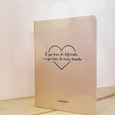 Caderno bege com texto motivacional dentro de coração em preto