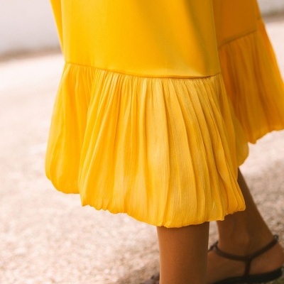 Vestido amarelo com barra franzida e sandálias castanhas