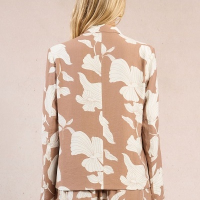 Casaco feminino castanho claro com padrão floral branco, visto de costas.