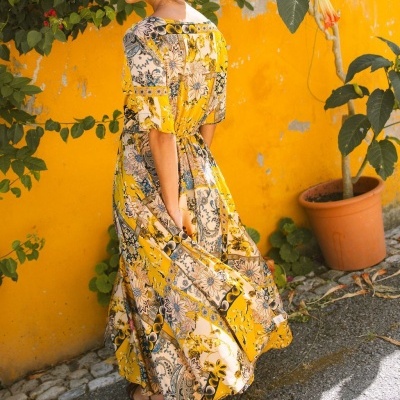 Vestido longo amarelo com padrão floral e cintura marcada