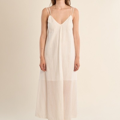 Vestido creme comprido com alças finas duplas e sandálias castanhas.