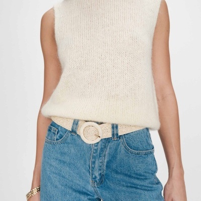 Colete de malha creme com jeans azuis e cinto creme trançado
