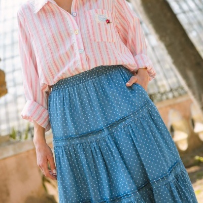 Camisa às riscas cor-de-rosa e saia azul com bolinhas brancas