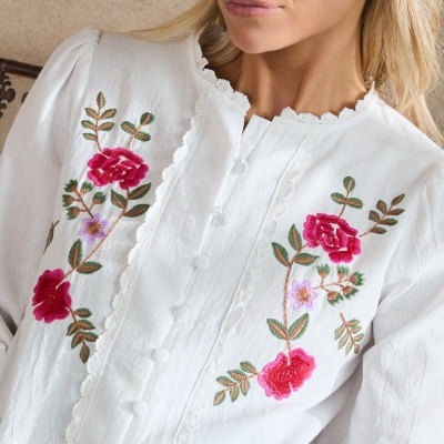 Blusa branca com bordados florais coloridos e botões encapados