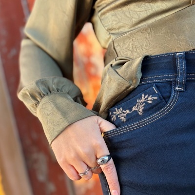 Calças de ganga com bordado floral e blusa castanha de tecido texturado com punhos franzidos