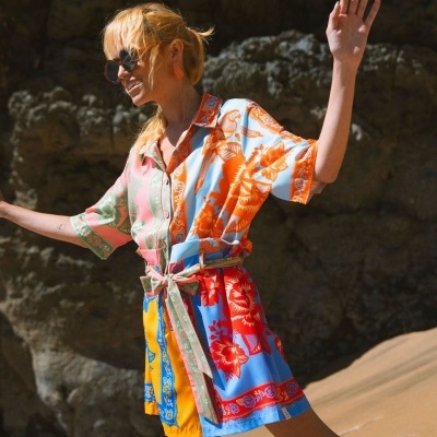 Vestido curto colorido com padrão floral usado por mulher na praia