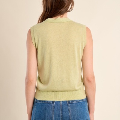 Camisola sem mangas verde clara com calças de ganga azuis vistas de costas